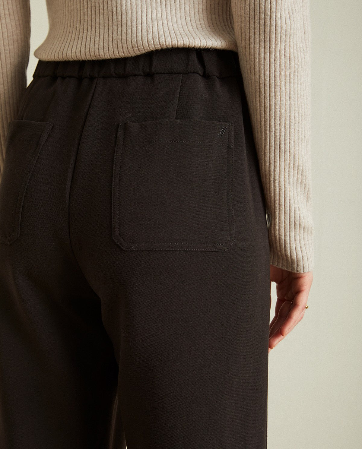 Pleated ankle trousers in black by YERSE